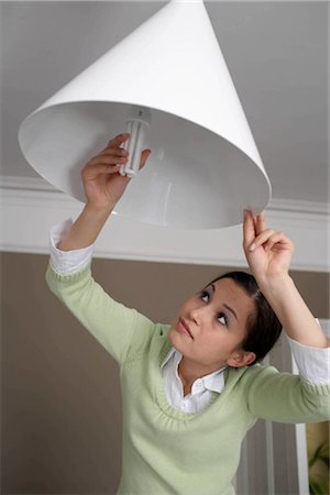 energy efficient - Woman changing lightbulb Stock Photo - Premium Royalty-Free, Code: 649-02424248