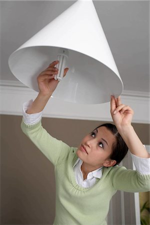 energy efficient compact fluorescent light bulb - Woman changing lightbulb Stock Photo - Premium Royalty-Free, Code: 649-02424248