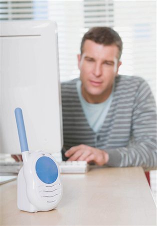 simsearch:649-02423471,k - Man listening to baby monitor at work Fotografie stock - Premium Royalty-Free, Codice: 649-02423467