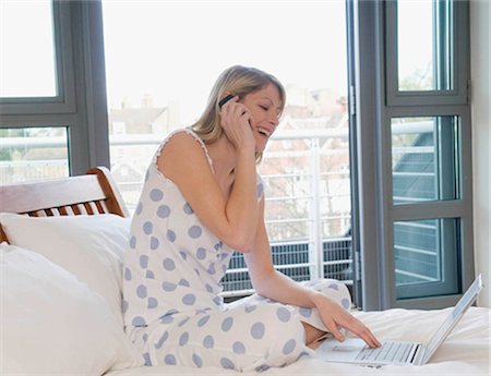 Femme travaillant à domicile dans le lit Photographie de stock - Premium Libres de Droits, Code: 649-02423475