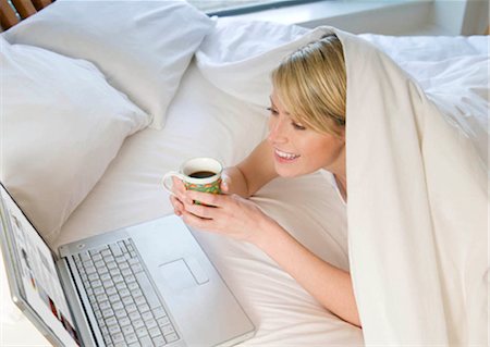 Female working on laptop in bed Foto de stock - Sin royalties Premium, Código: 649-02423482