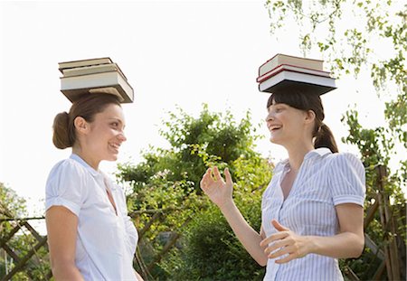 Équilibrage des livres sur la tête des femmes d'affaires Photographie de stock - Premium Libres de Droits, Code: 649-02423539