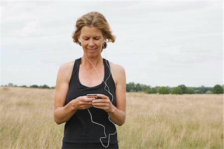 surrey - Woman runner listening to music Foto de stock - Sin royalties Premium, Código: 649-02423721