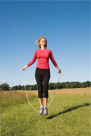 skipping - Woman skipping in field Stock Photo - Premium Royalty-Free, Code: 649-02423732