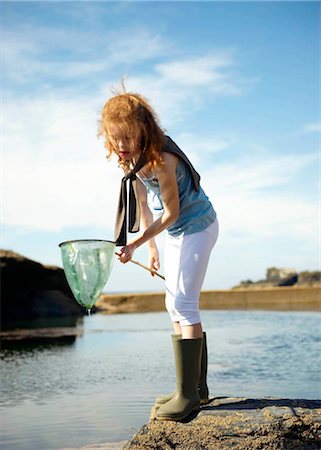 pozza di marea - Young girl looking in net at rock pool Fotografie stock - Premium Royalty-Free, Codice: 649-02423976