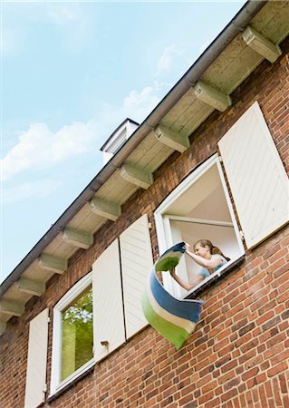 Woman cleaning a rug out a window Foto de stock - Sin royalties Premium, Código: 649-02665368