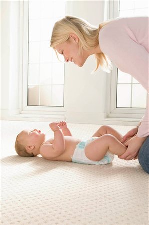 diapering mother to baby - Une mère souriant à son bébé Photographie de stock - Premium Libres de Droits, Code: 649-02665505