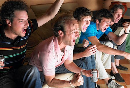 Men watching television, holding beers Stock Photo - Premium Royalty-Free, Code: 649-02666277