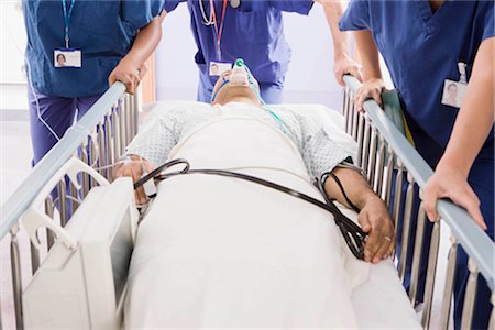 diagnostic - Trois médecins poussant un patient dans son lit Photographie de stock - Premium Libres de Droits, Code: 649-02666332