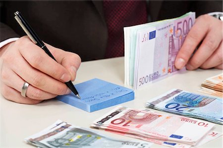 person holding stacks of paper - Money on desk Stock Photo - Premium Royalty-Free, Code: 649-02666365