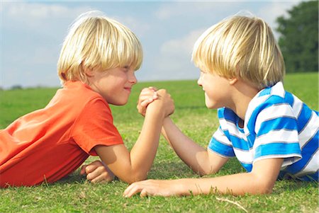 rivalidade entre irmãos - two boys arm wrestling Foto de stock - Royalty Free Premium, Número: 649-02666833