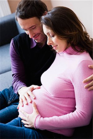 Pregnant woman and man sitting on couch Stock Photo - Premium Royalty-Free, Code: 649-02731303