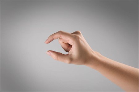 Woman's hand gesturing a small amount Stock Photo by ©itardiusz 3481217