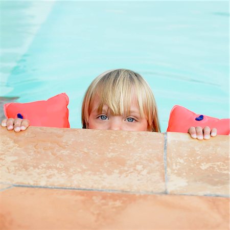 Girl in swimming pool with rubber rings Stock Photo - Premium Royalty-Free, Code: 649-02731940