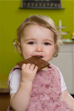 simsearch:649-02053991,k - Young girl biting into chocolate bar Fotografie stock - Premium Royalty-Free, Codice: 649-02732506