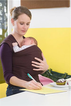 simsearch:649-02732530,k - Mother with baby in baby sling,  writing Foto de stock - Royalty Free Premium, Número: 649-02732530