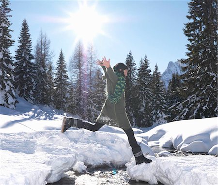 Woman jumping across stream Stock Photo - Premium Royalty-Free, Code: 649-02732766