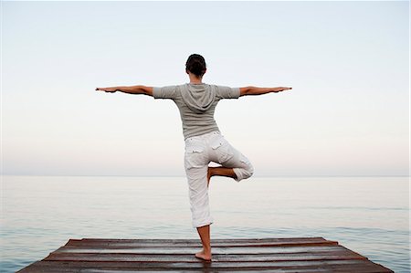 Young Woman Doing Yoga At Jetty Stock Photo - Premium Royalty-Free, Code: 649-03008584