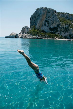 simsearch:649-02731278,k - Woman diving into blue water from boat Foto de stock - Royalty Free Premium, Número: 649-03008729
