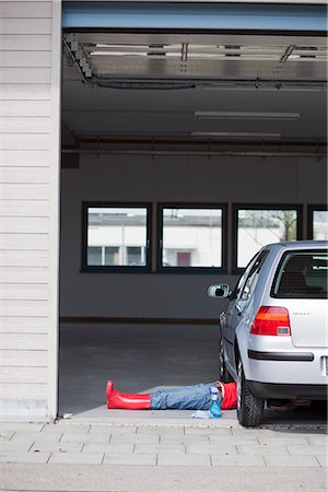 young girl lying under car cleaning Stock Photo - Premium Royalty-Free, Code: 649-03009012