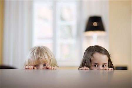 esconderse - children looking over table edge Foto de stock - Sin royalties Premium, Código: 649-03009763