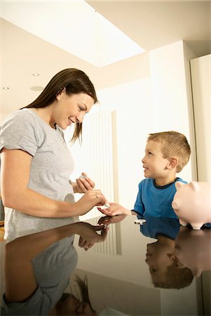 family in rain - mum handing boy money Stock Photo - Premium Royalty-Free, Code: 649-03009855