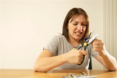 frustrated shopper - woman cutting credit cards Stock Photo - Premium Royalty-Free, Code: 649-03009859