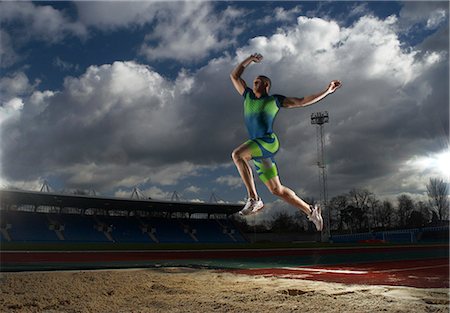 salto em distância - athlete doing long jump Foto de stock - Royalty Free Premium, Número: 649-03009878