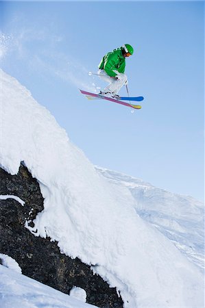 Man in green dropping a cliff face. Stock Photo - Premium Royalty-Free, Code: 649-03077568