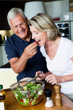 photo of a woman feeding her husband food - Senior Couple Preparing Salad Foto de stock - Sin royalties Premium, Código: 649-03077718