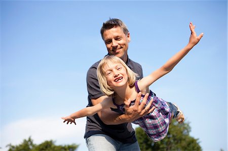 parent and child outside activity - Father Playing Airplane with Girl Stock Photo - Premium Royalty-Free, Code: 649-03077742