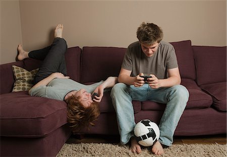 friends talking sofa and two people - Boys using mobile phones Stock Photo - Premium Royalty-Free, Code: 649-03077861