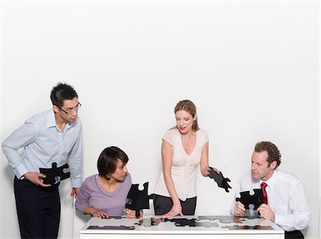 Four business people doing a jigsaw Stock Photo - Premium Royalty-Free, Code: 649-03077982