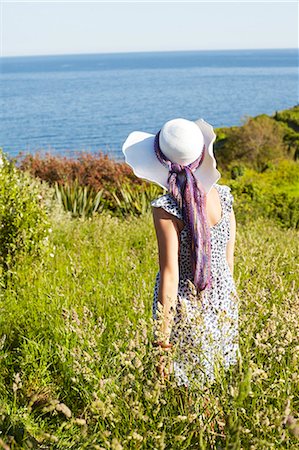 A girl in a field looking at the sea Stock Photo - Premium Royalty-Free, Code: 649-03078123