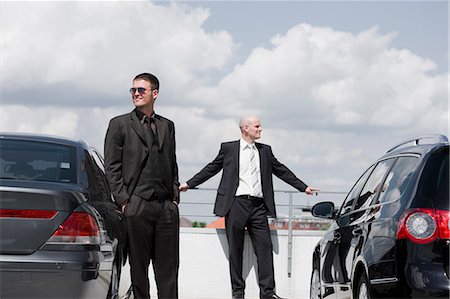two business men standing between cars Stock Photo - Premium Royalty-Free, Code: 649-03154644