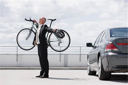 man carrying bycicle stretching near car Stock Photo - Premium Royalty-Free, Code: 649-03154665