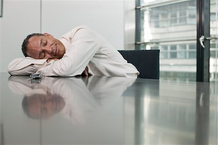 man leaing on table eyes closed Stock Photo - Premium Royalty-Free, Code: 649-03153850