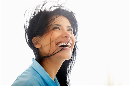 Woman with wind in her hair, smiling Stock Photo - Premium Royalty-Free, Code: 649-03153891