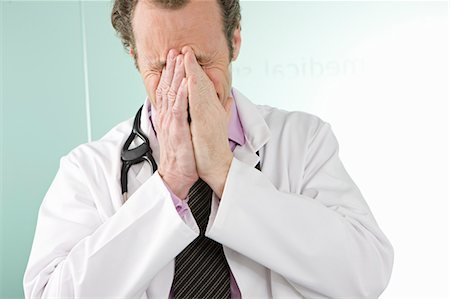 simsearch:649-06040340,k - A doctor holding his hands over his face Stock Photo - Premium Royalty-Free, Code: 649-03153960