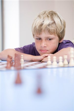 Boy playing chess Foto de stock - Royalty Free Premium, Número: 649-03294210