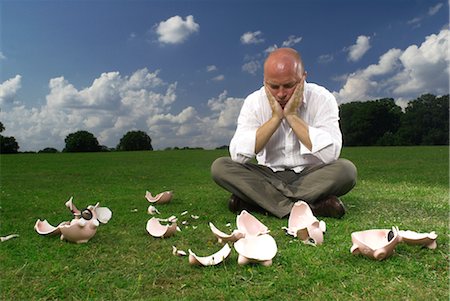 financial nest egg - man and smashed piggy banks Stock Photo - Premium Royalty-Free, Code: 649-03294430