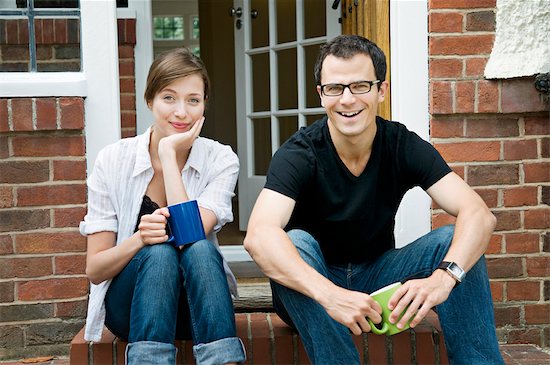 A young couple sitting on their doorstep Photographie de stock - Premium Libres de Droits, Le code de l’image : 649-03294695