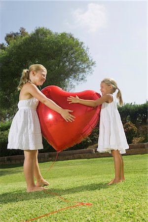 Young girls hugging red heart balloon Stock Photo - Premium Royalty-Free, Code: 649-03294737