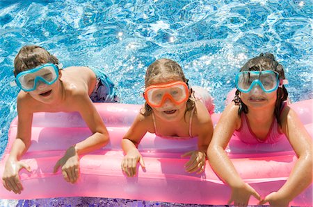 friends in pool - Three kids on a inflatable in a pool Stock Photo - Premium Royalty-Free, Code: 649-03295925