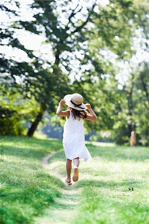 straw hat - girl running down a path Stock Photo - Premium Royalty-Free, Code: 649-03296083