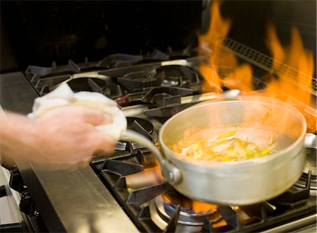 A flaming pan cooking on a hob Stock Photo - Premium Royalty-Free, Code: 649-03297501