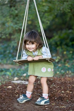 Petite fille jouant sur la balançoire bois Photographie de stock - Premium Libres de Droits, Code: 649-03297545