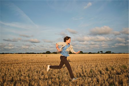 Une jeune fille qui traverse un champ Photographie de stock - Premium Libres de Droits, Code: 649-03297701