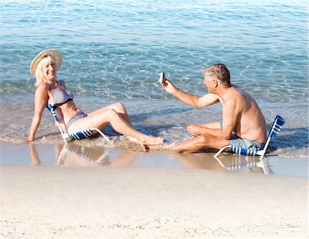 females posing together at the beach - Senior male taking a photo of a woman Stock Photo - Premium Royalty-Free, Code: 649-03291883