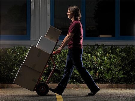 delivery (goods and services) - man moving boxes at night Stock Photo - Premium Royalty-Free, Code: 649-03292133